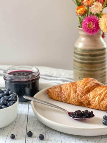 Confiture de bleuets, croissant et pot de fleurs